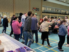 Many different people with disabilities dancing and singing. photo taken from behind the dancers