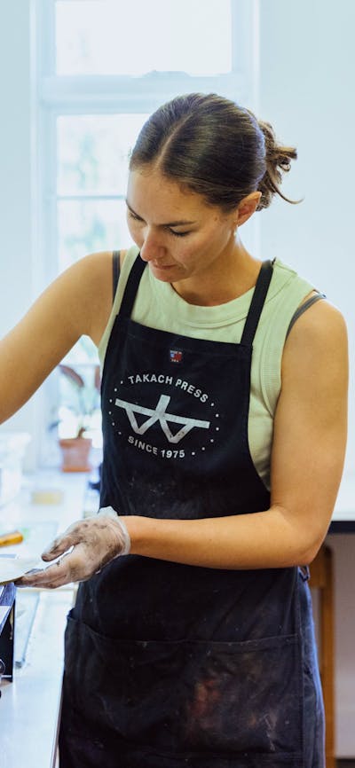 A woman prepares an etching using inks and paper
