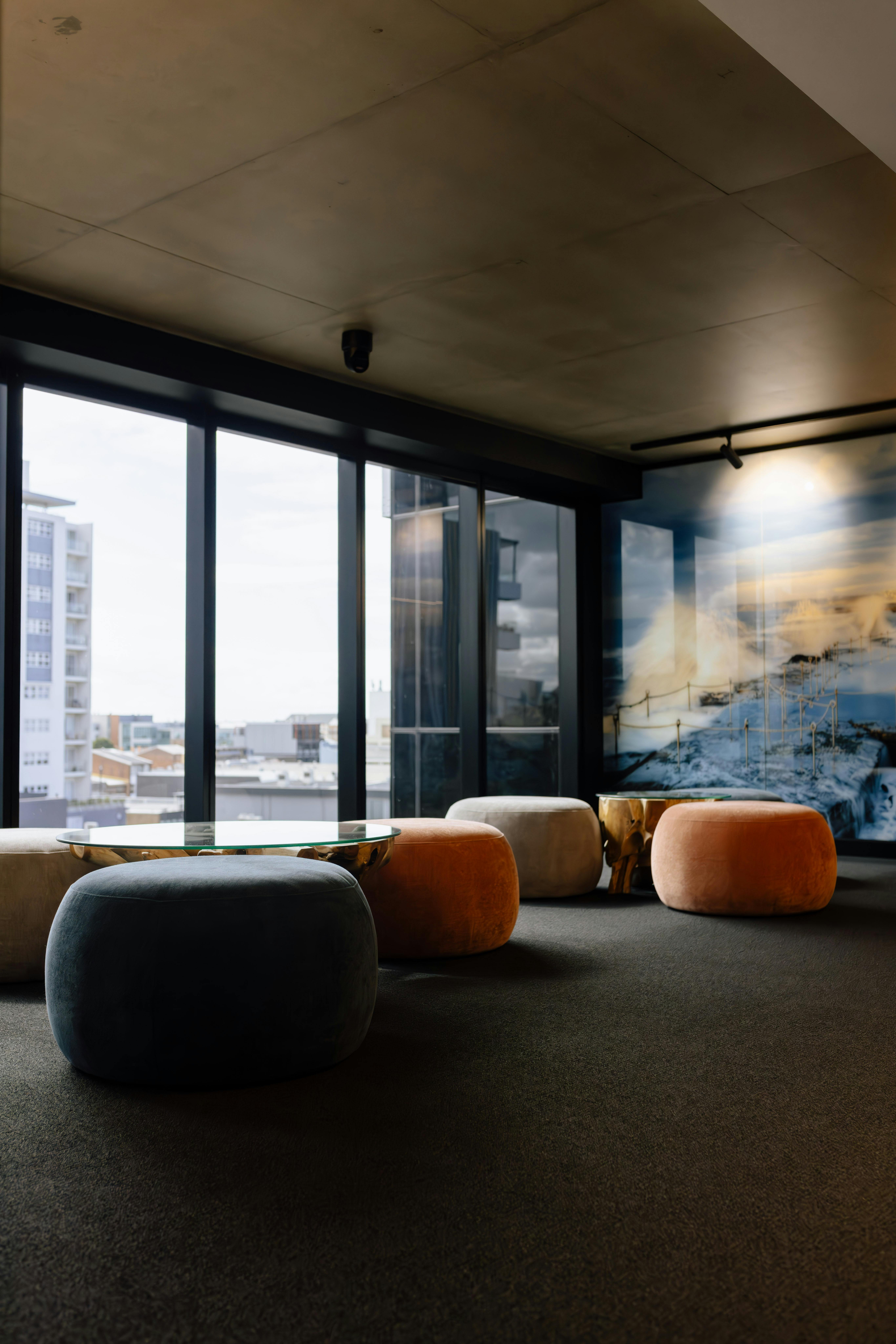 Modern lobby seating area with plush seats, a coffee table, and natural light