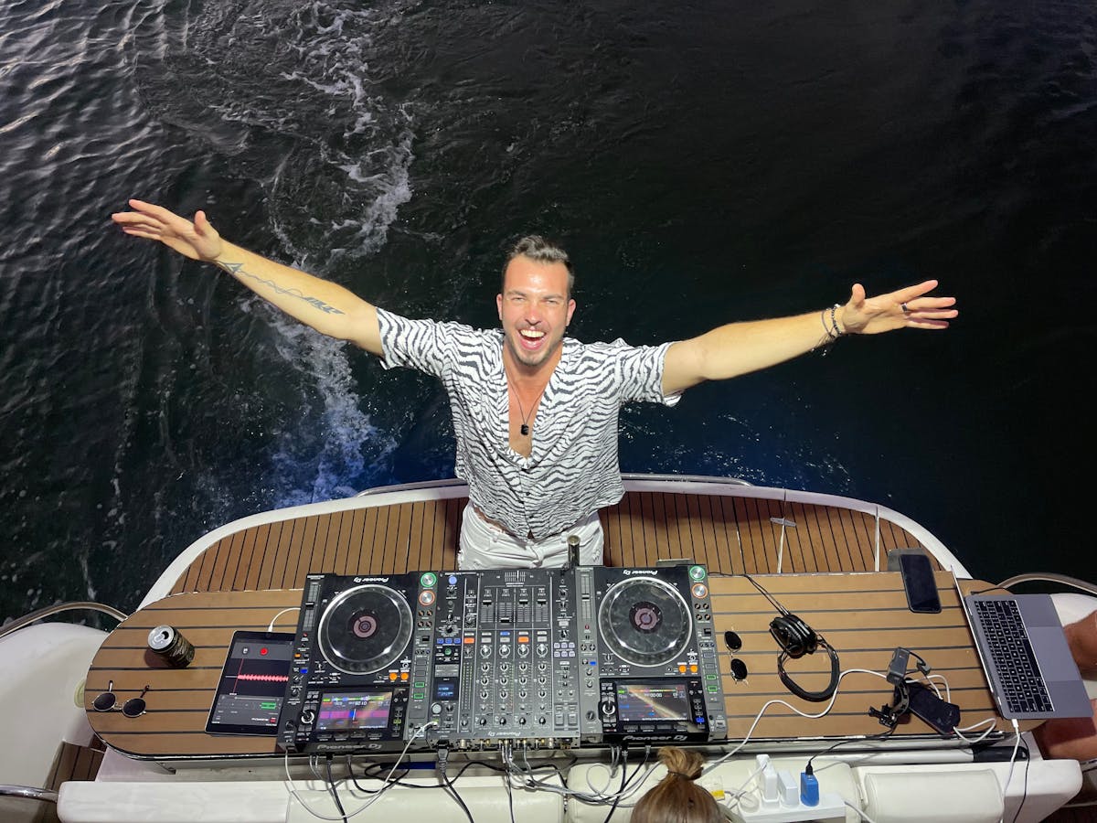 DJ playing music on the rear deck of a luxury yacht during a celebration on the Gold Coast. DJ playing music on the rear deck of a luxury yacht during a celebration on the Gold Coast.