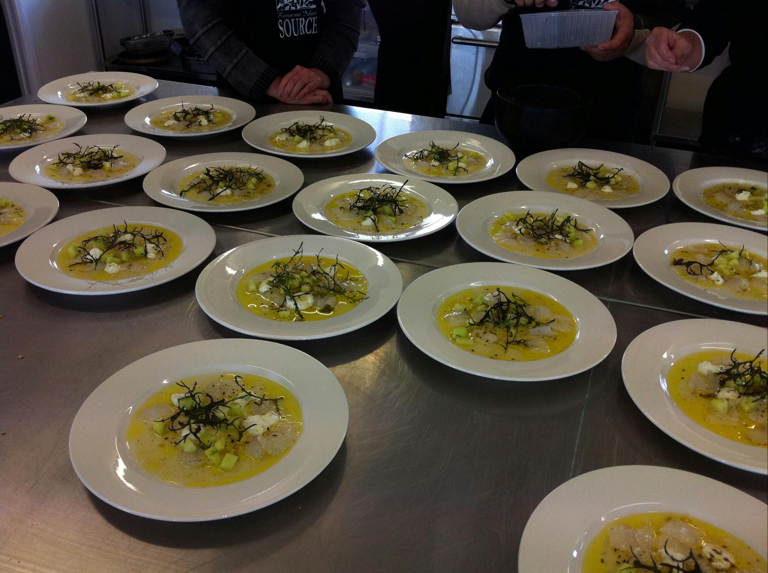 Multiple plates of food laid out on a stainless steel bench