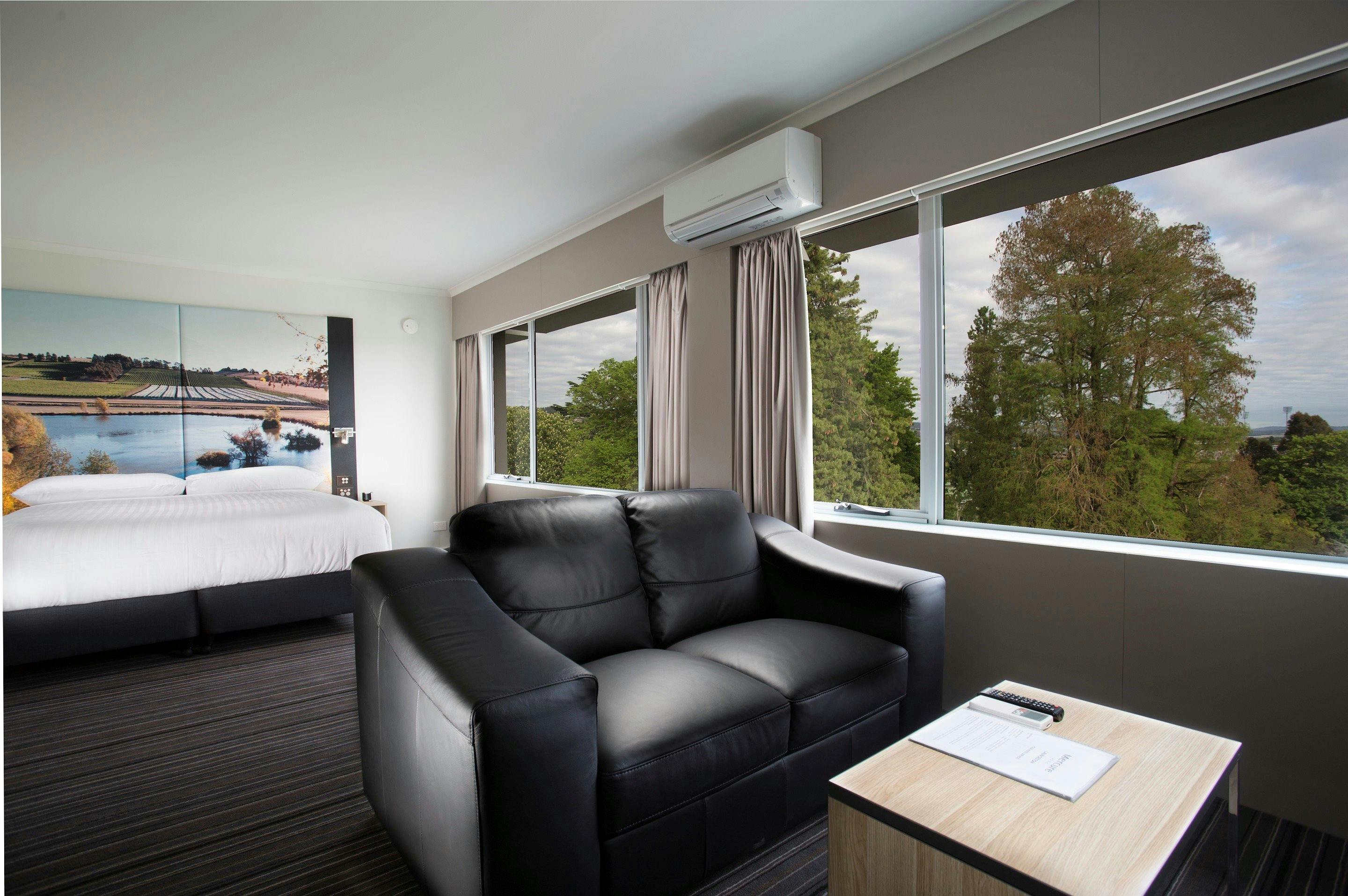 Gues accommodation room, with king bed, large windows with park view.
