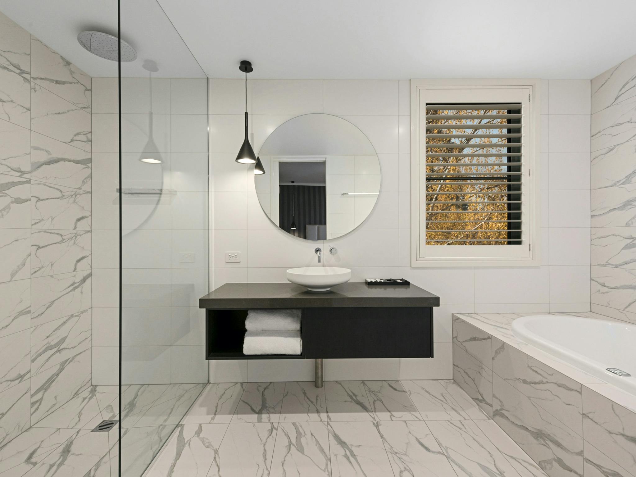 Modern, renovated bathroom with large walk in shower, spa bath and window