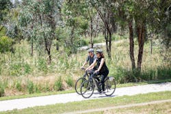Two people cycling on bike  path