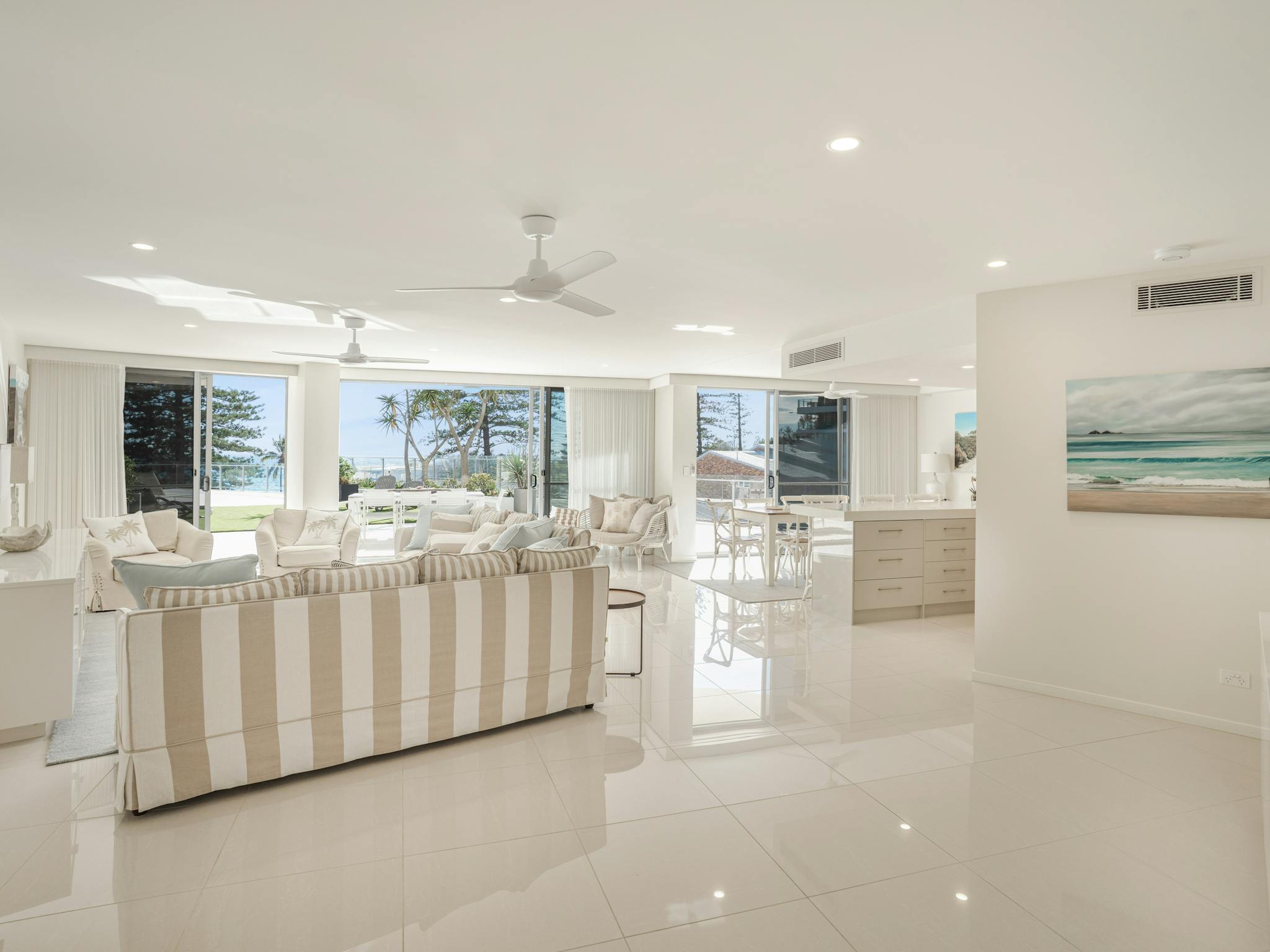 Inviting lounge with tan and white striped sofas, high-gloss tiled floors, and expansive oceanview Inviting lounge with tan and white striped sofas, high-gloss tiled floors, and expansive oceanview