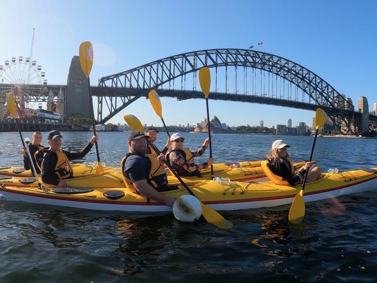 Team kayaking photo under the Sydney Harbour Bridge
