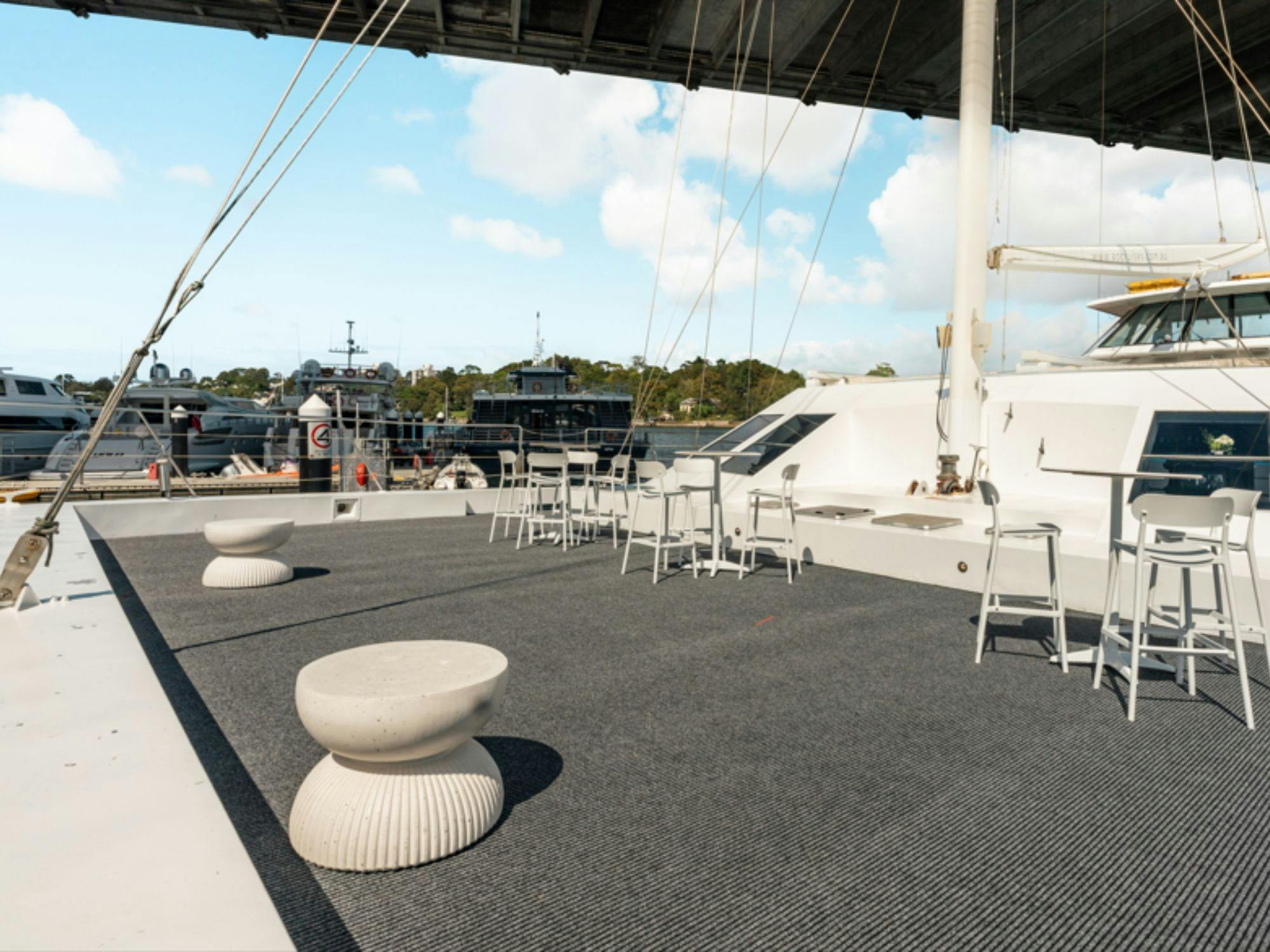 Empty front deck of Aussie Magic with seating and Anzac Bridge in the background