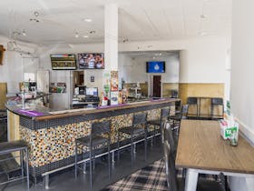 The bar with mosaic tiling at The Bushmanu2019s Arms, featuring TVs and a variety of seating options