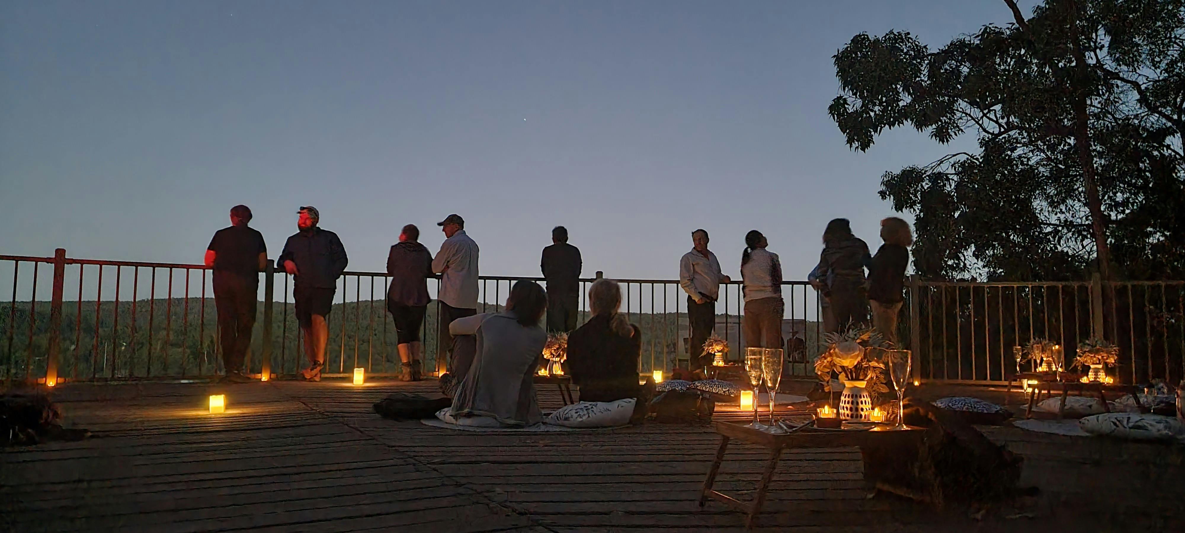Romantic atmosphere on lookout with lots of candles and couples looking up at stars