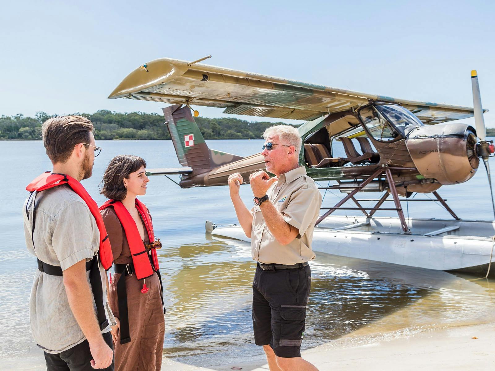 Two passengers and pilot talking before the flight in seaplane.