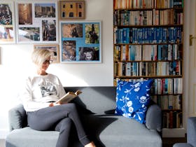 Guest sitting on sofa reading a book
