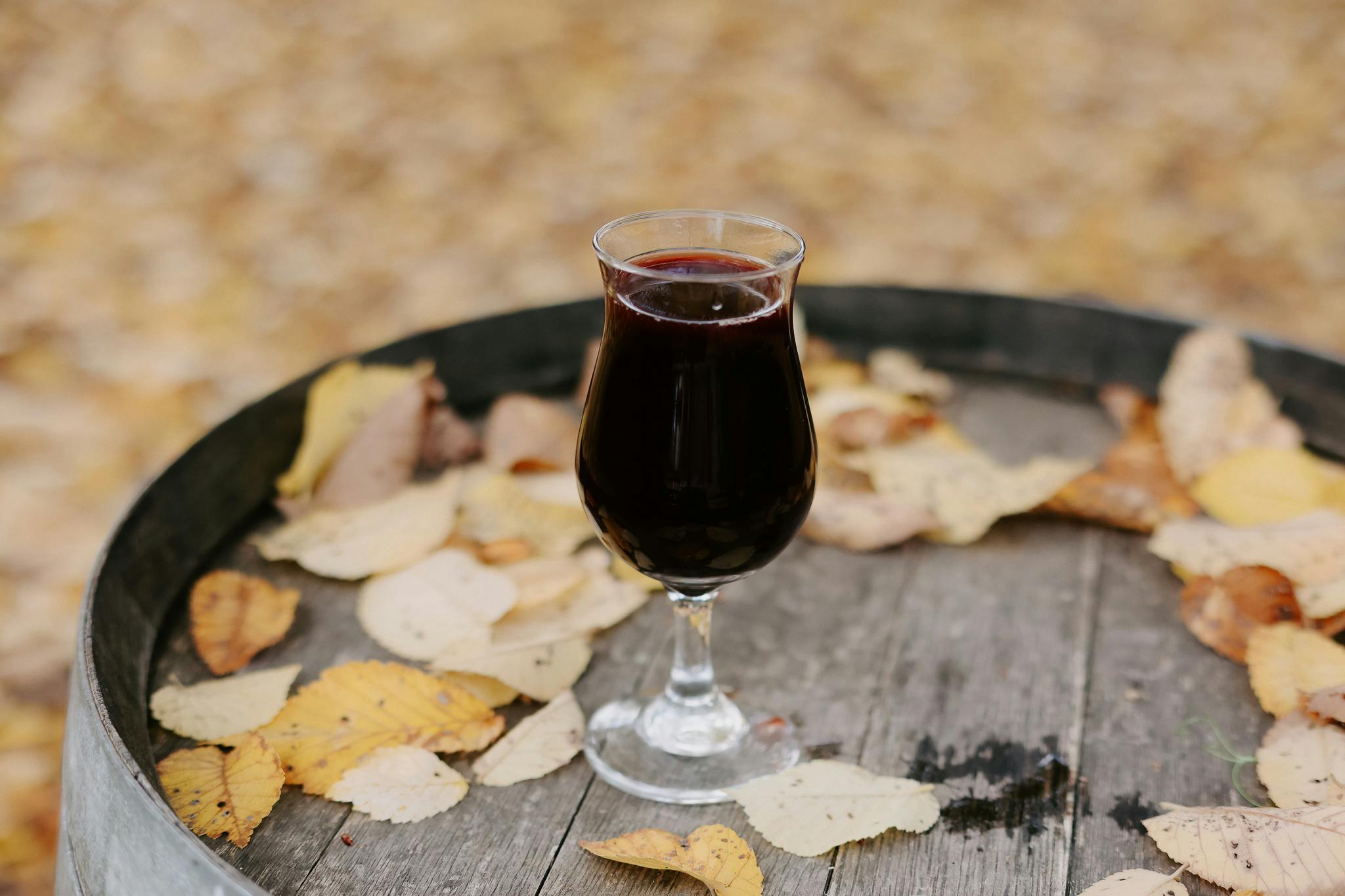 Glass of wine placed on a barrel