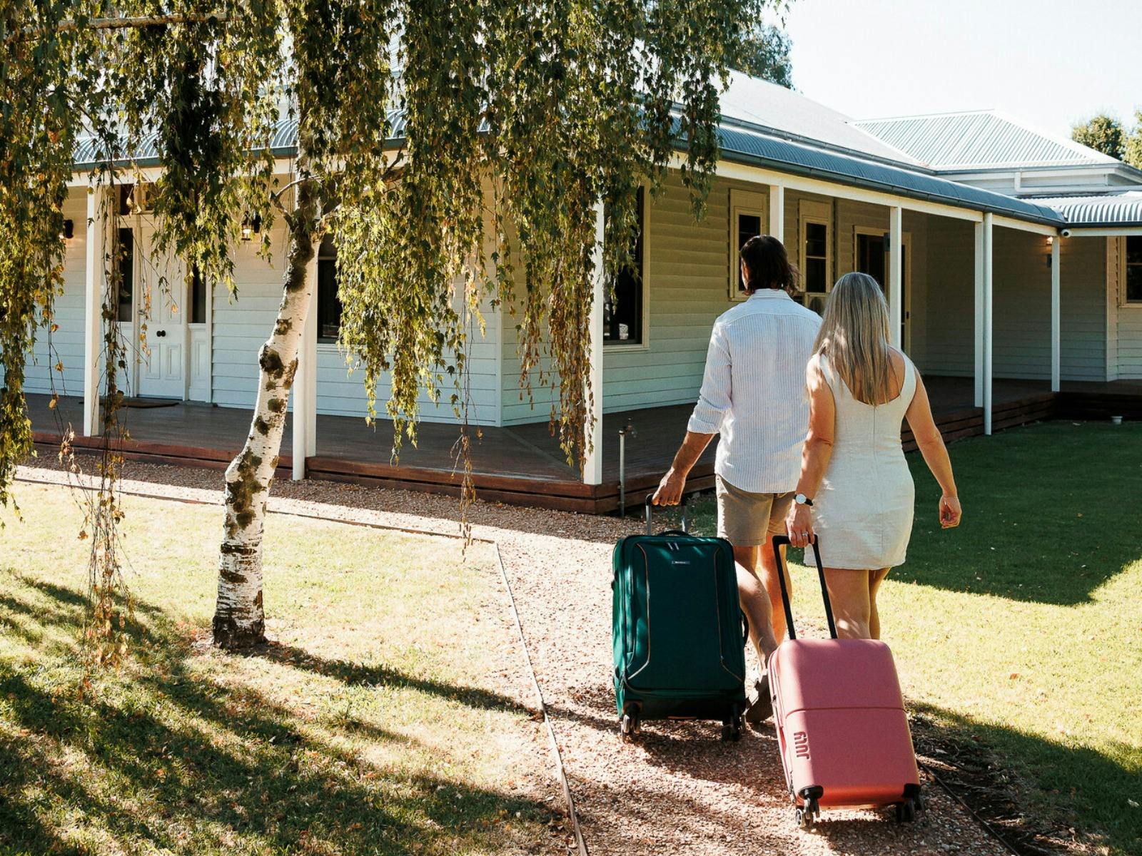 Guests walking with their bags up the silver birch path to the front door of Dal Zotto Homestead