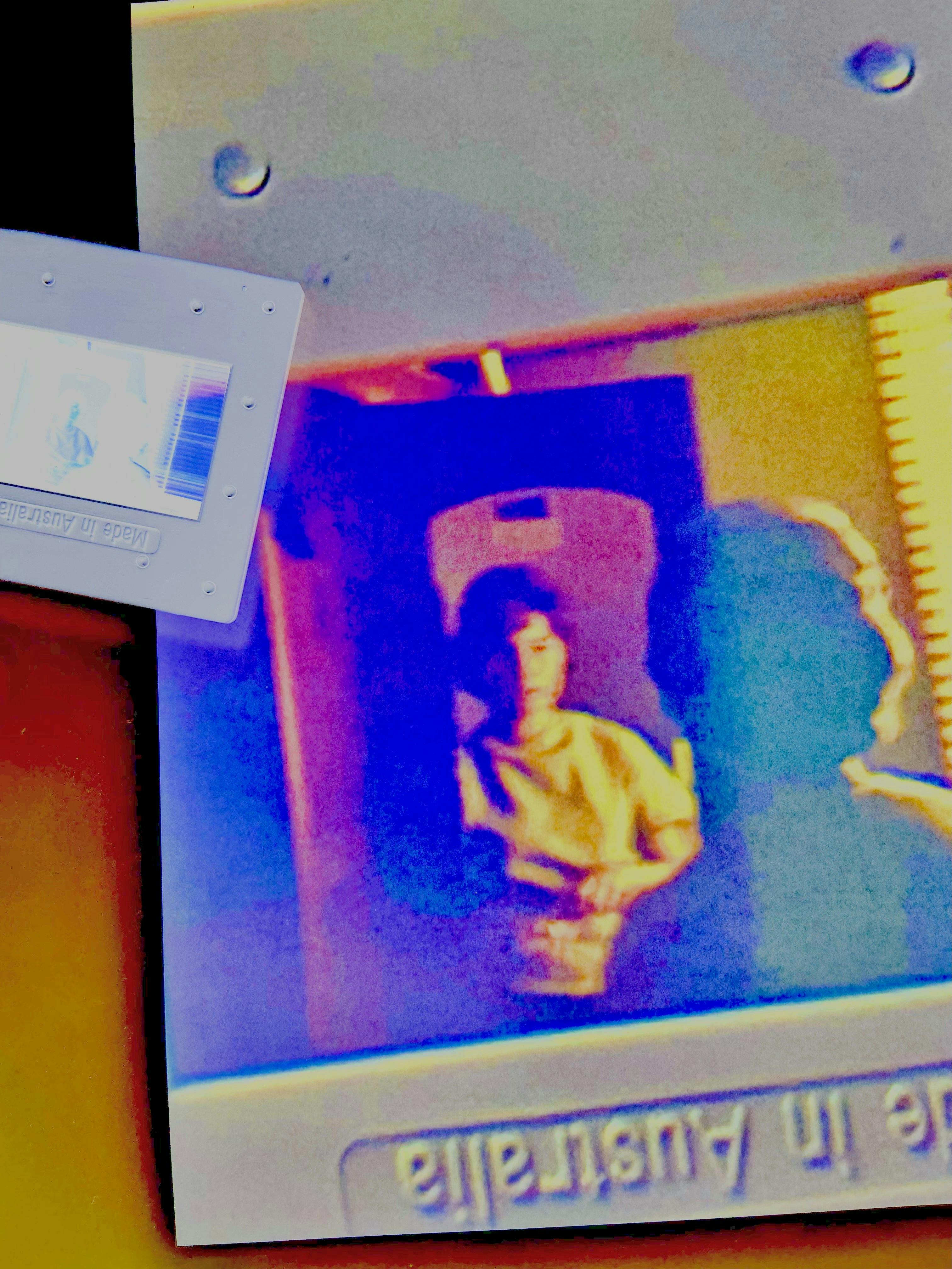 Abstracted photographic in high contrast blue purple and yellow with a reflected figure in doorway