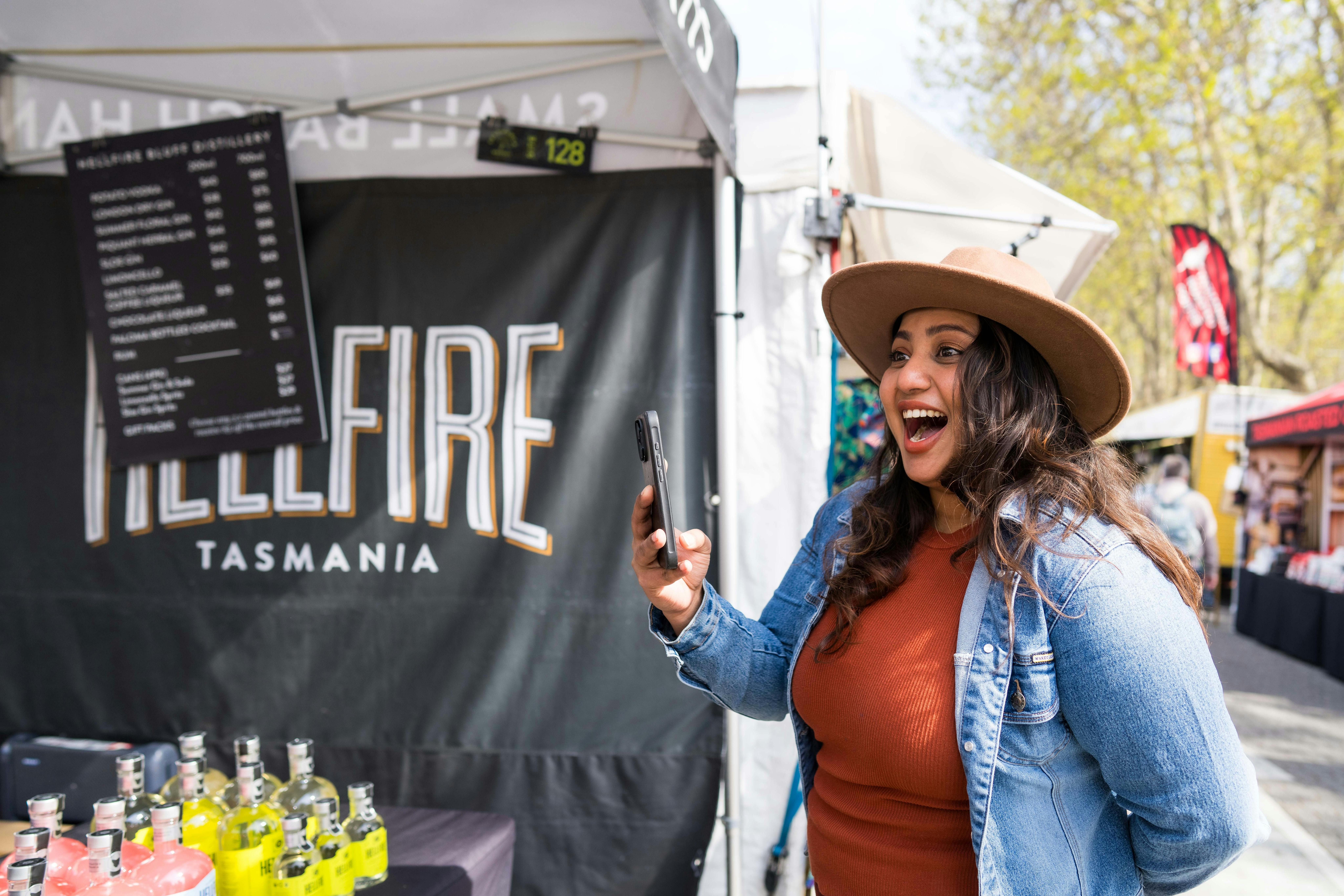 A girl smiles with delight while taking a photo on her phone