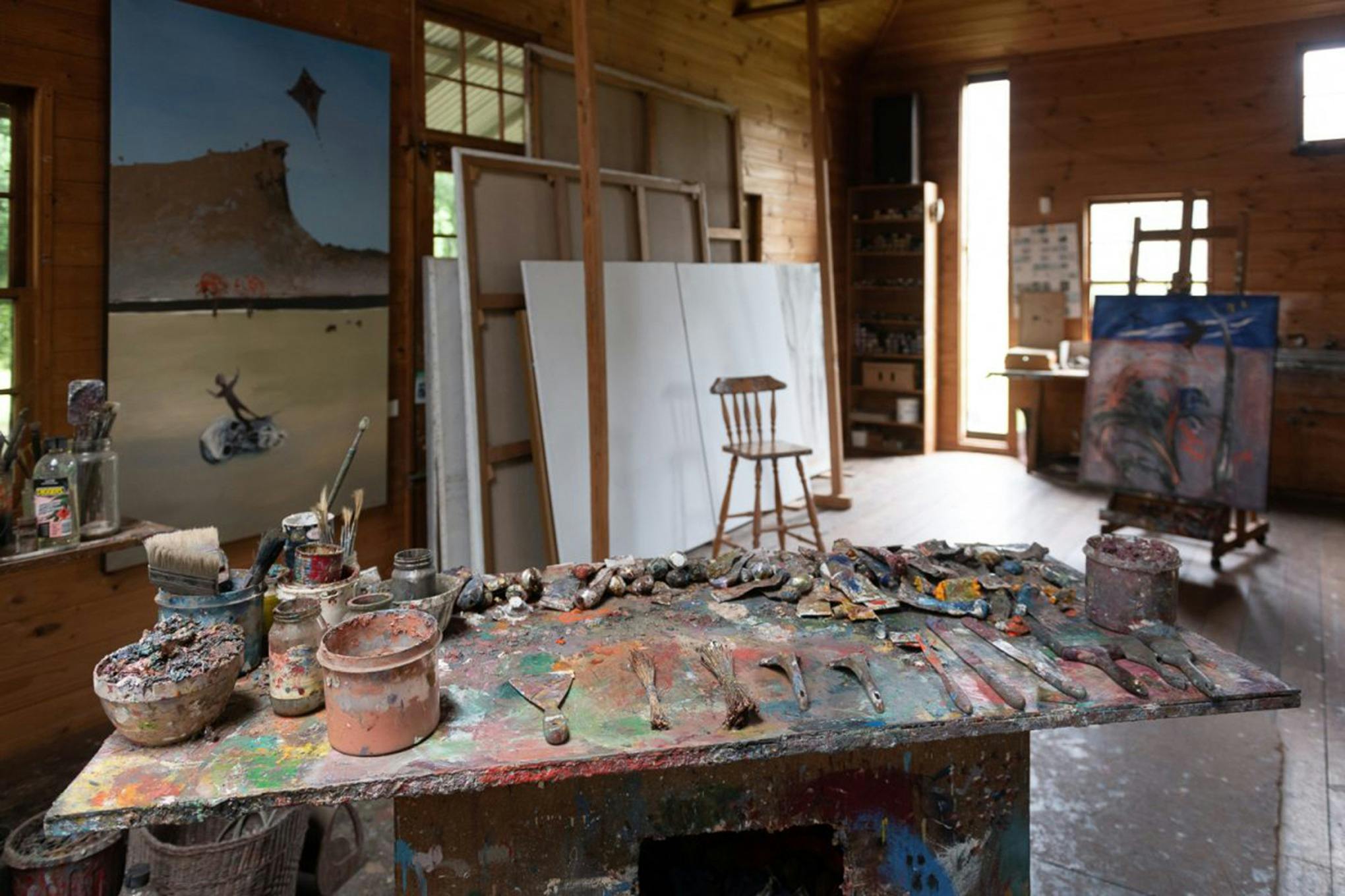 An artist's studio with paint all over a bench