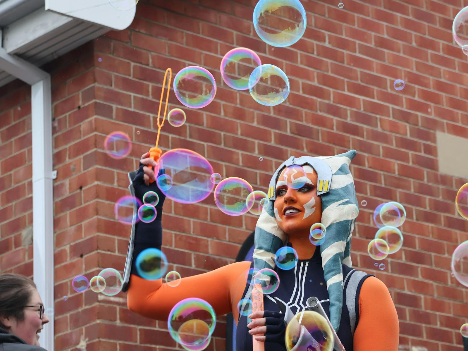 Girl in costume at Pop Bam blowing bubbles
