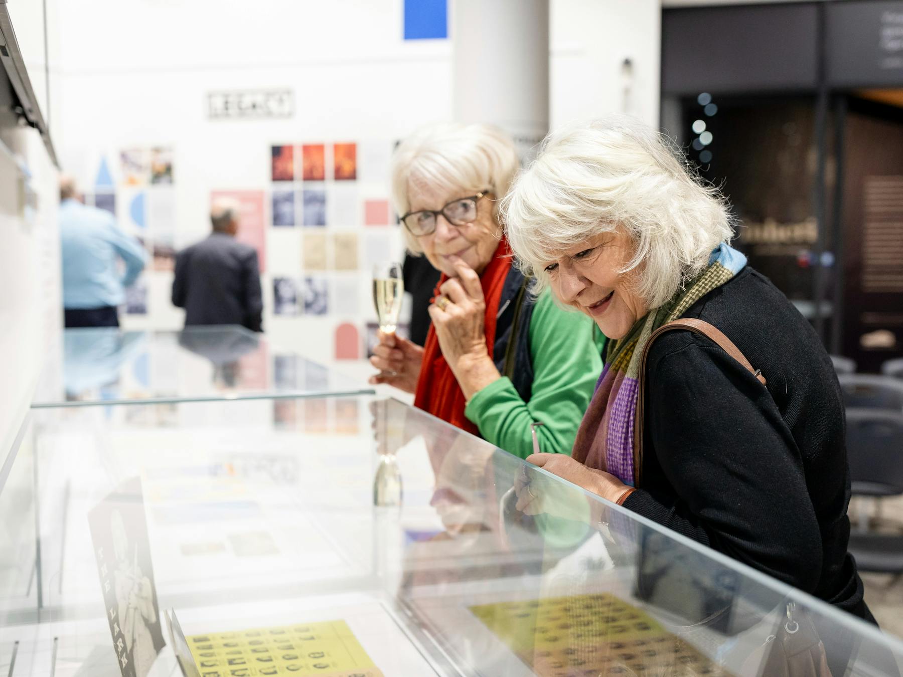 Visitors look at objects in the 'ASSEMBLE: Orange Festival of Arts 1965-1987' exhibition