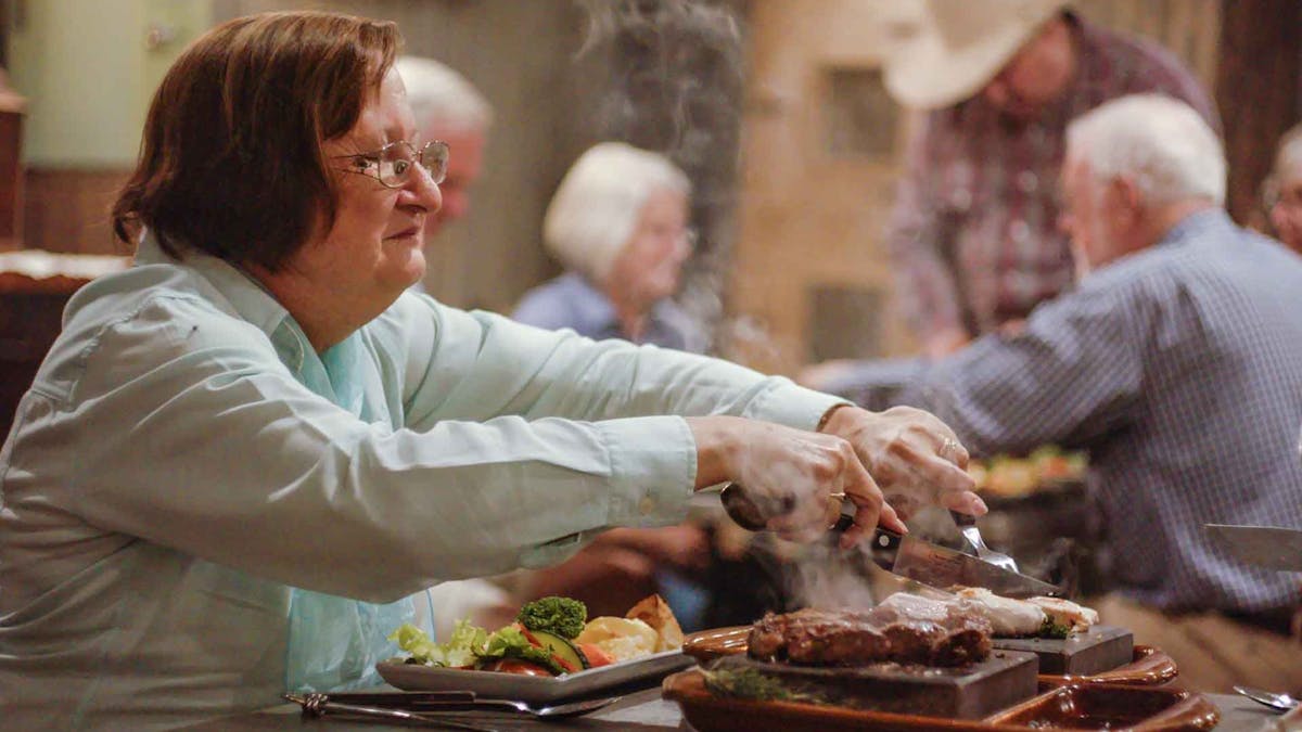 Guests enjoying the Stonegrill Dining Experience with cooking steak on hot stones