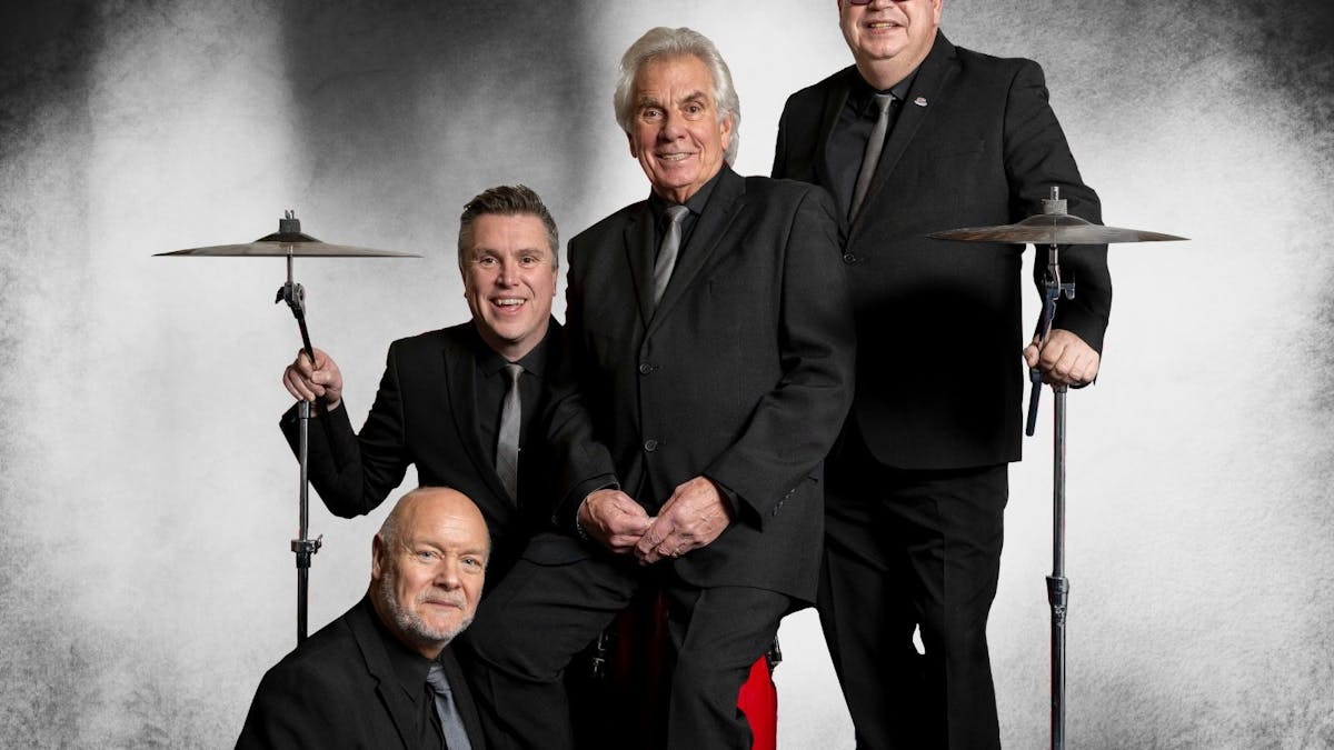 4 men in dark suits with drum symbols on each end