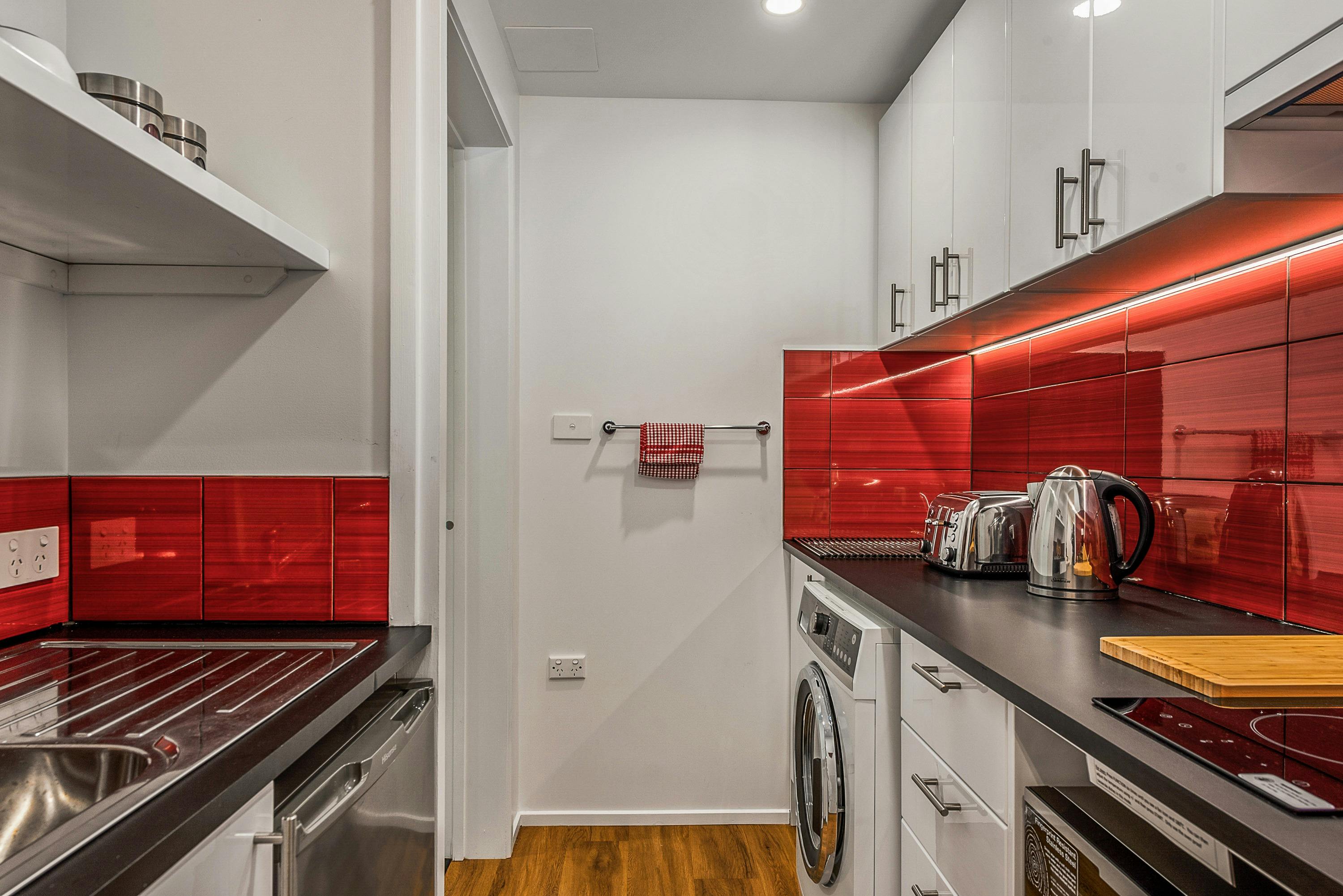 Fully equipped galley kitchen with cooking facilities and laundry appliances