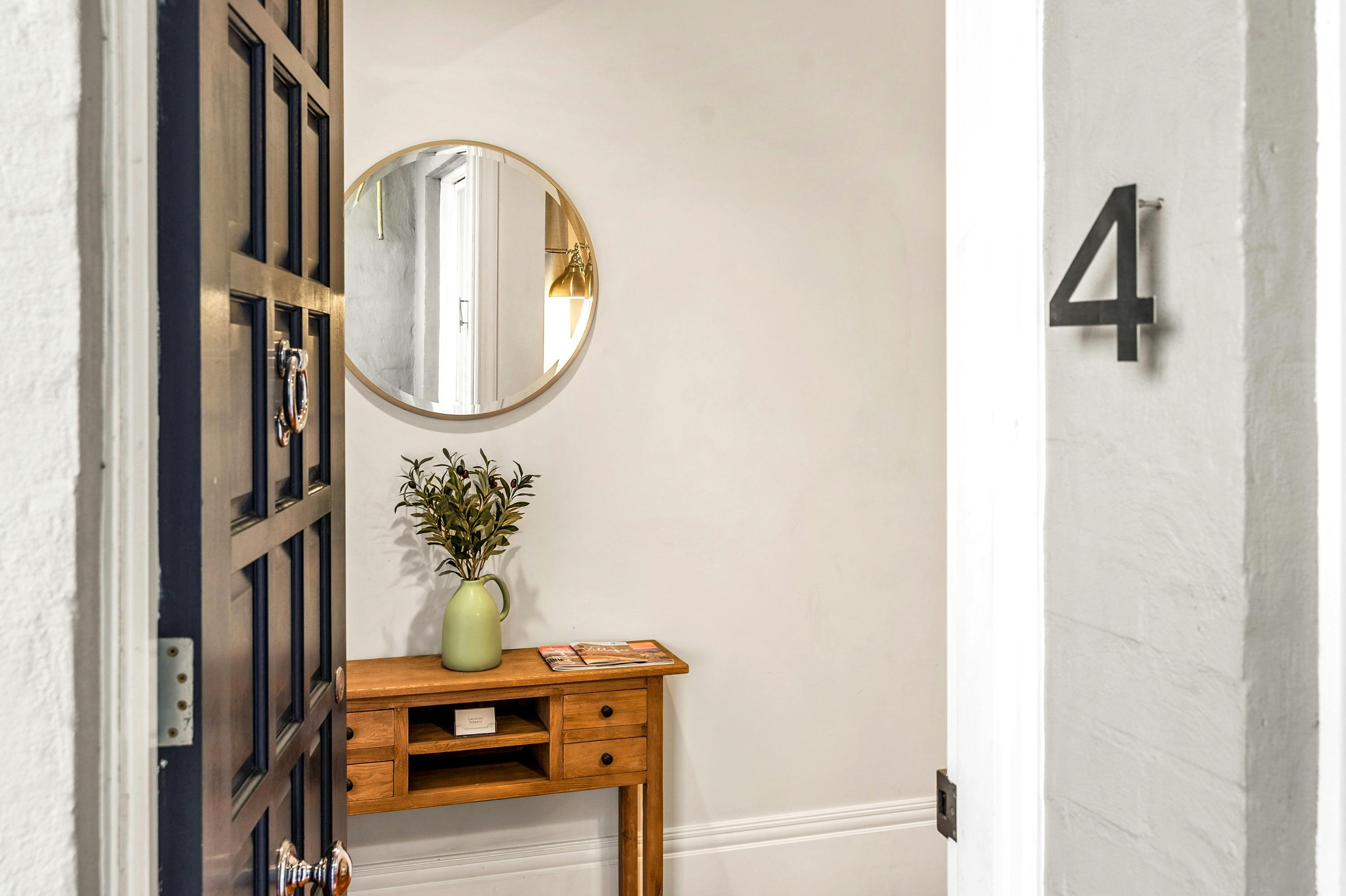 front door, round mirror, hall stand, flowers