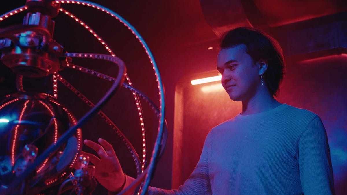 A glowing reflective orb reactor with a young adult reaching his hand towards it in curiosity
