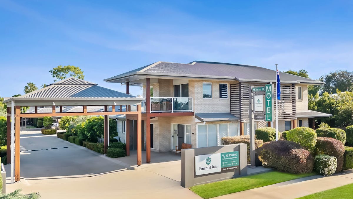 The modern exterior of the Emerald Inn motel with well maintained gardens & grounds.