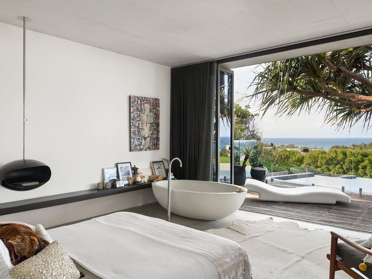 Luxurious master suite, adorned with a furnished deck, and a bath with a view Luxurious master suite, adorned with a furnished deck, and a bath with a view
