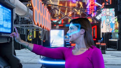 Lady with a glowing VR headset using a digital screen in an escape room