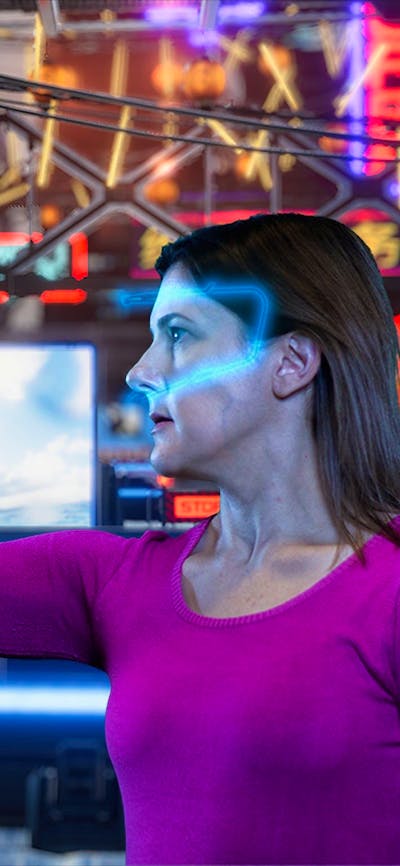 Lady with a glowing VR headset using a digital screen in an escape room