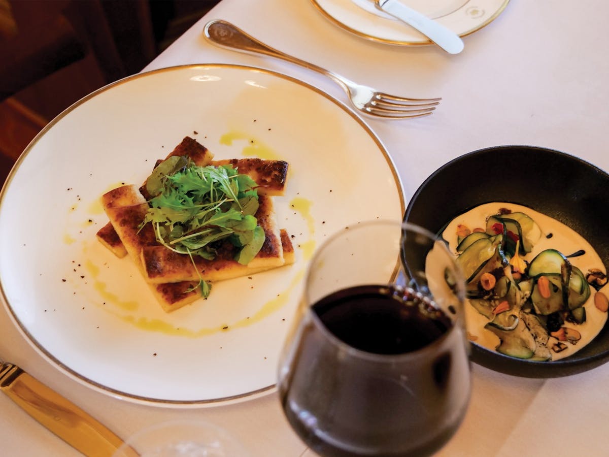 Elegant meal presentation on a gold-rimmed plate, with a glass of red wine. Elegant meal presentation on a gold-rimmed plate, with a glass of red wine.