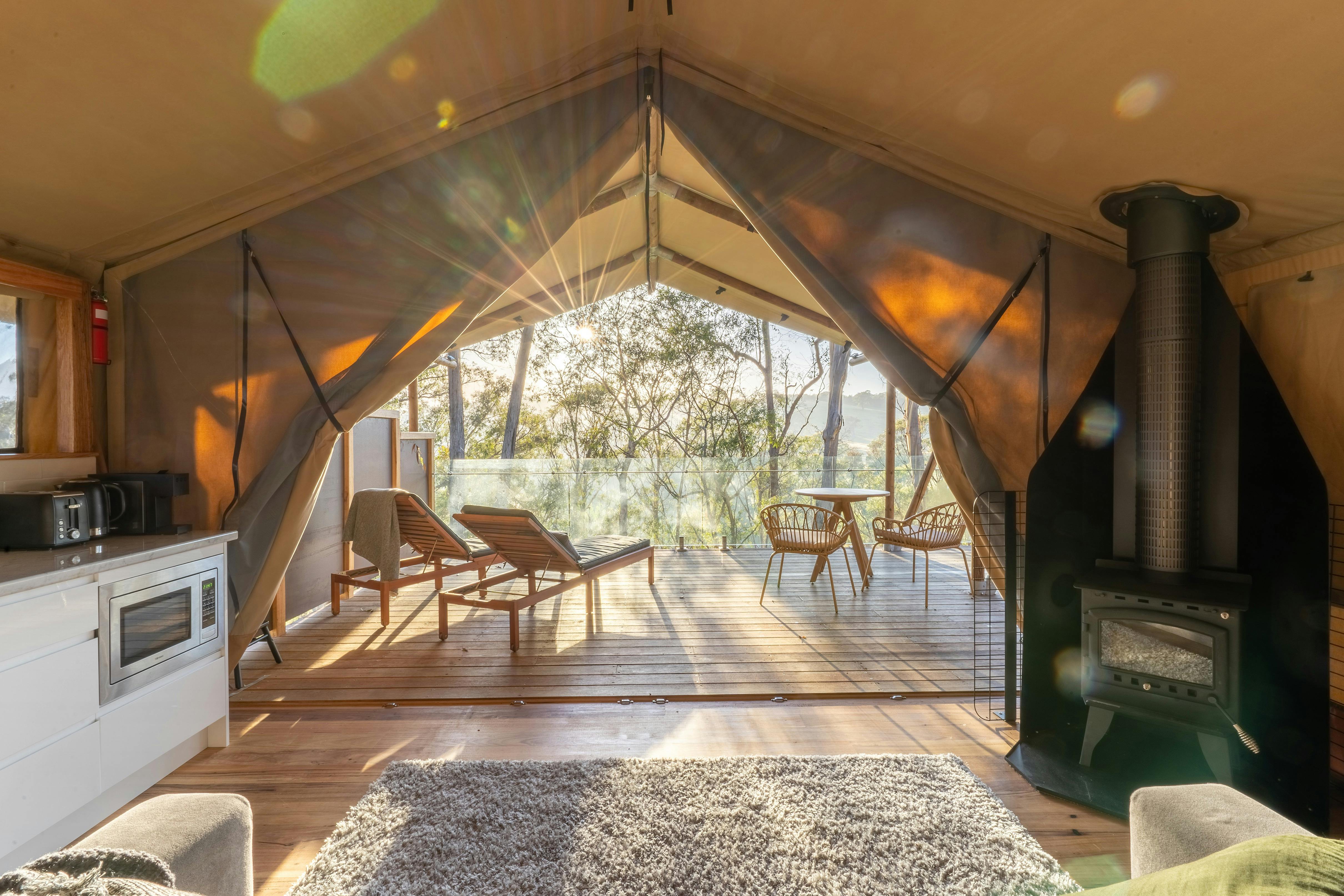 テントのフラップから差し込む朝日と、その背後にあるベランダと屋外の景色