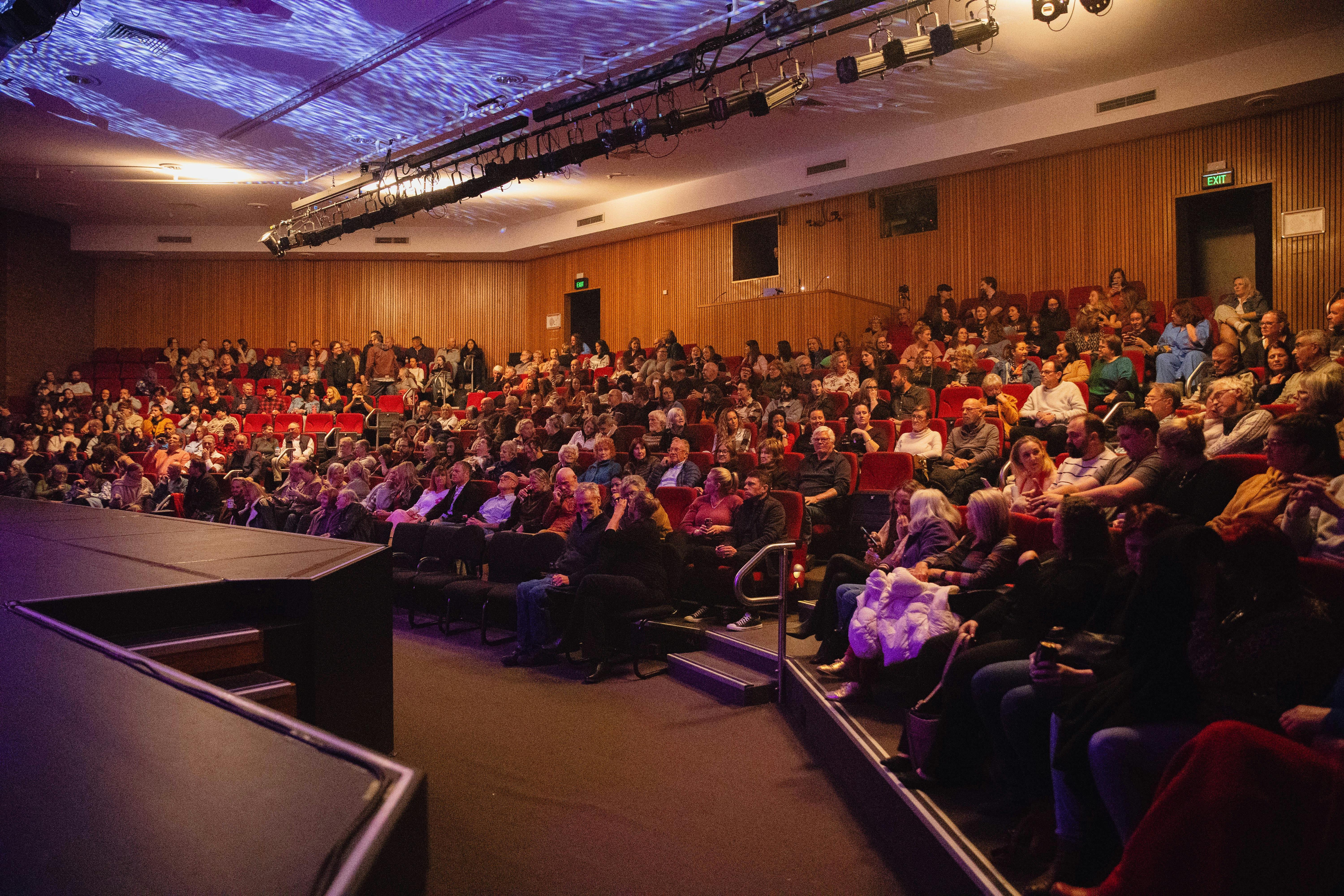 The theatre is full of audience members. There are 362 people sat in tiered seating.