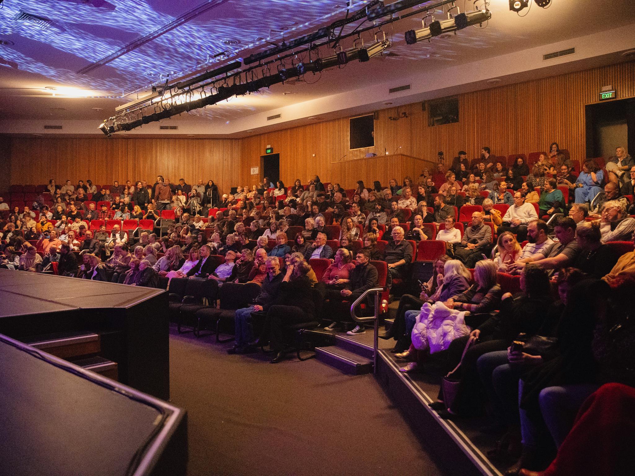 The theatre is full of audience members. There are 362 people sat in tiered seating.