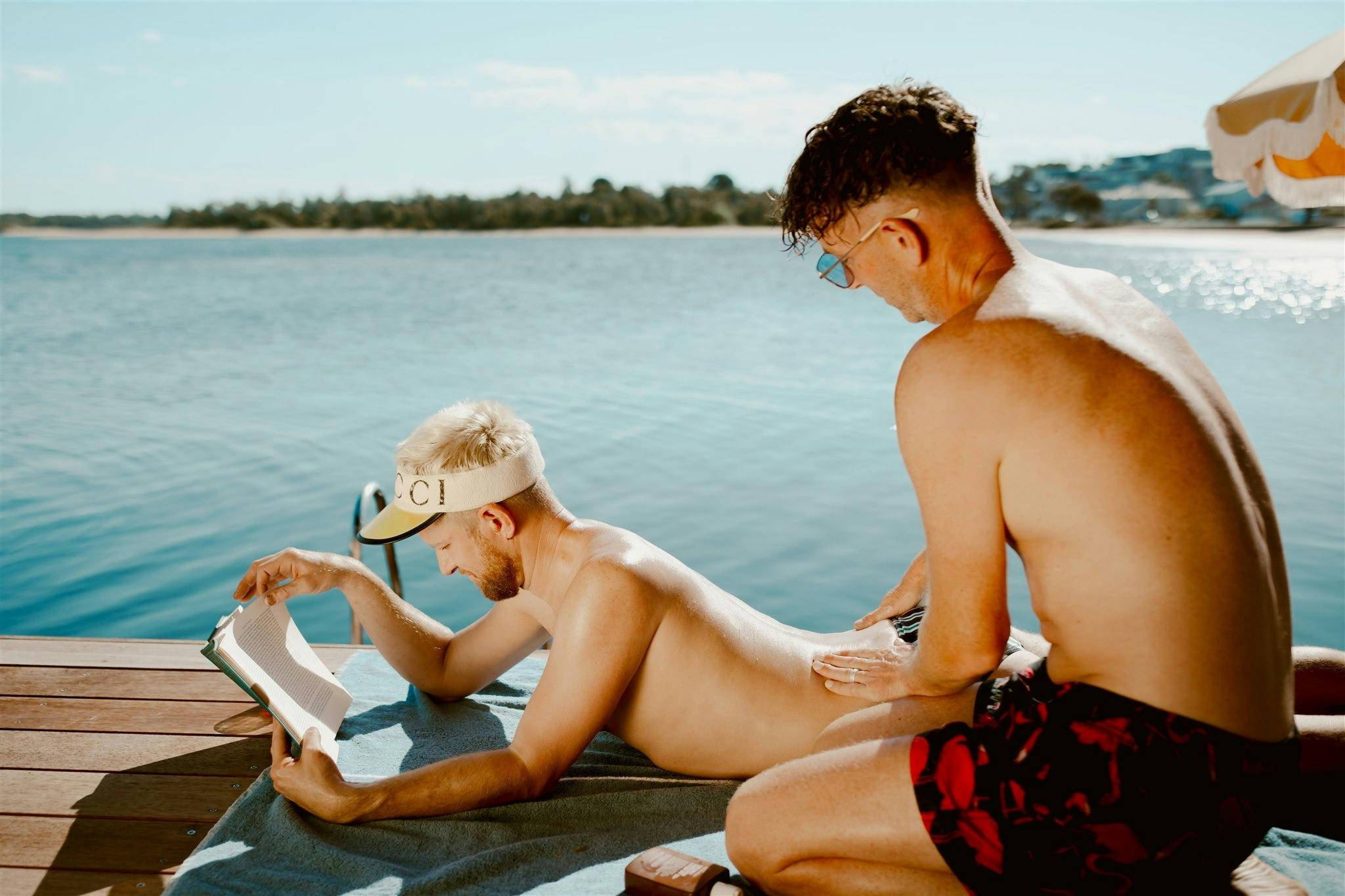 Person applying sunscreen on the other person on the deck