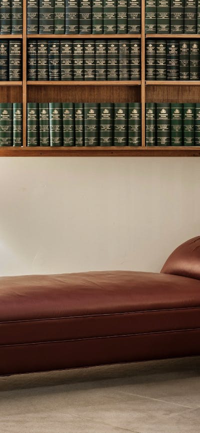 A leather lounge below a bookcase