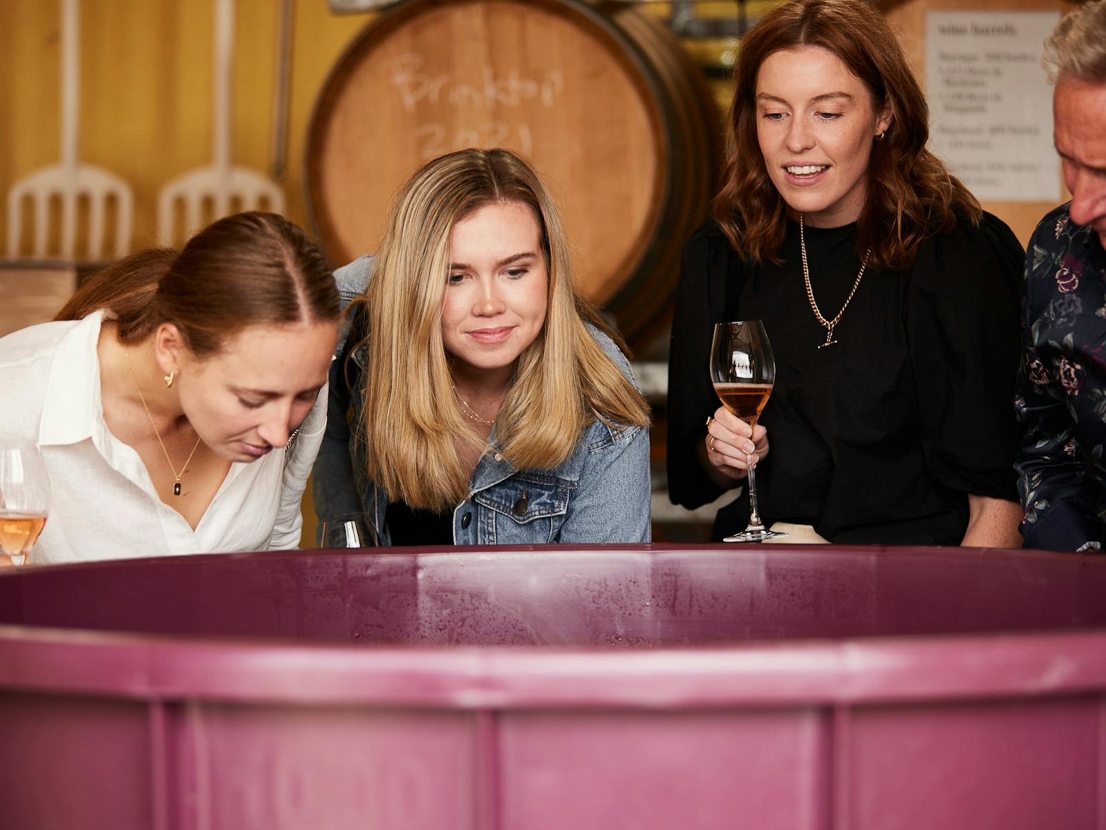 Three people smelling wine being made