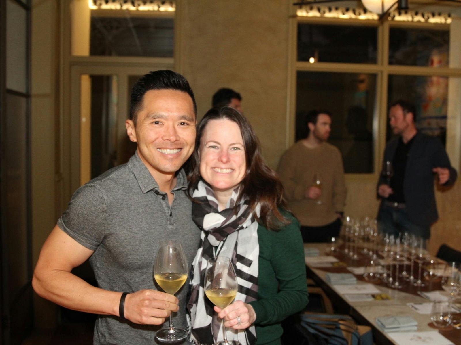 A man and a woman holding red wine glasses at a previous Aphelion wine dinner