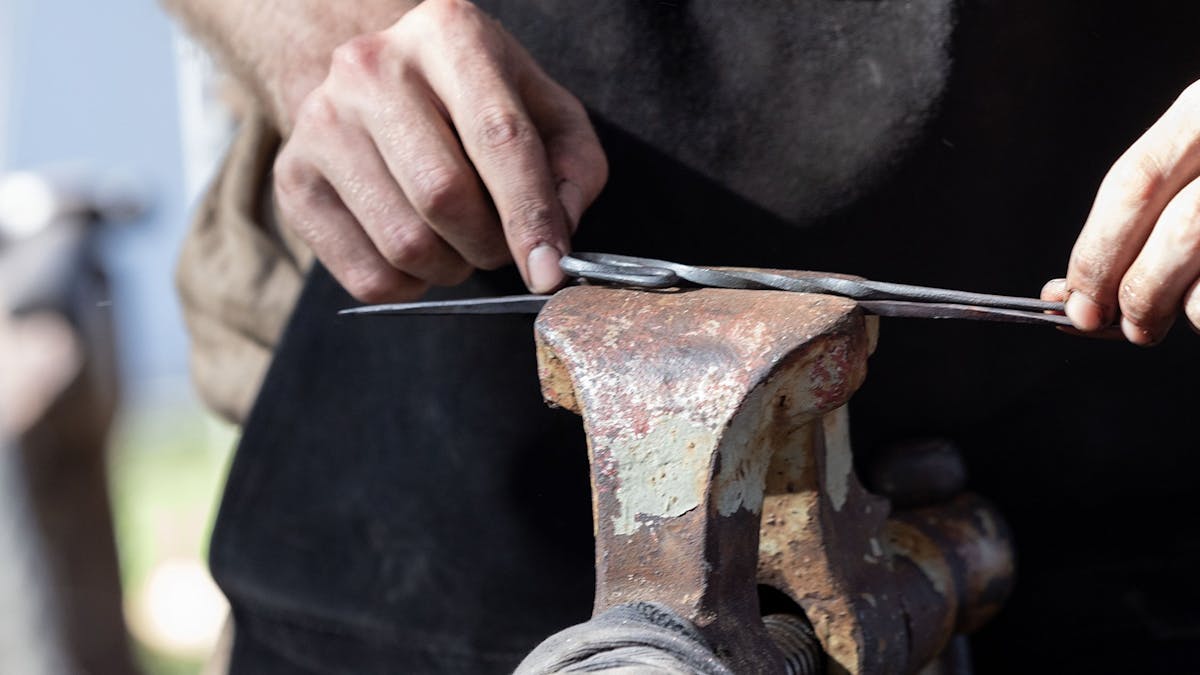 close up of a blacksmith at an anvil