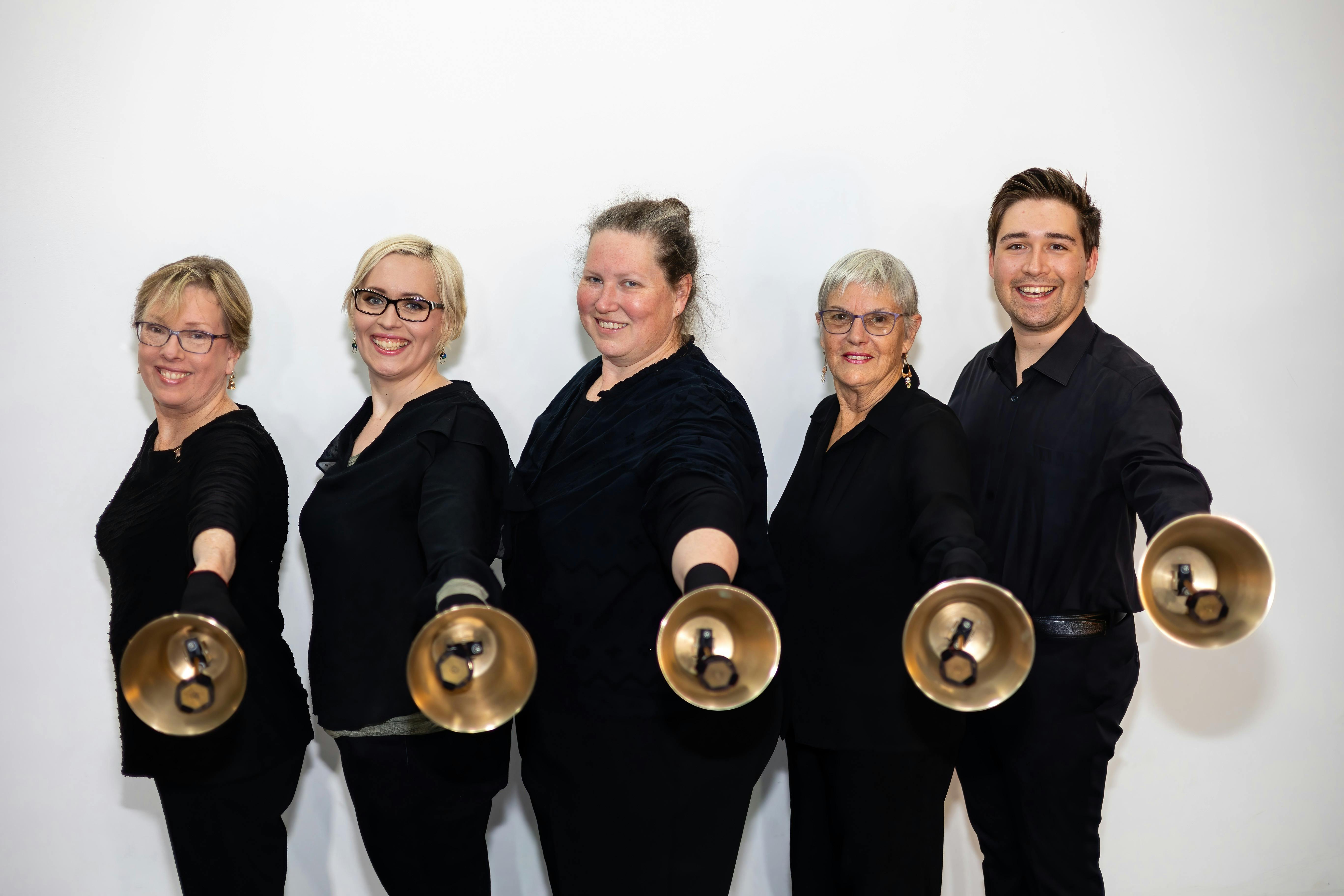 Small bell ringing ensemble holding bells