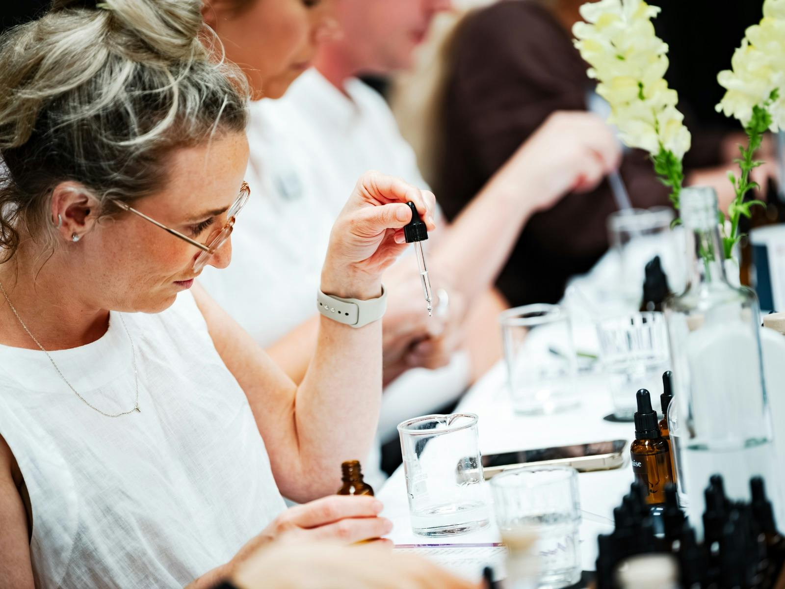 A young professional woman carefully measures out her Blending Class ingredients with a pipette