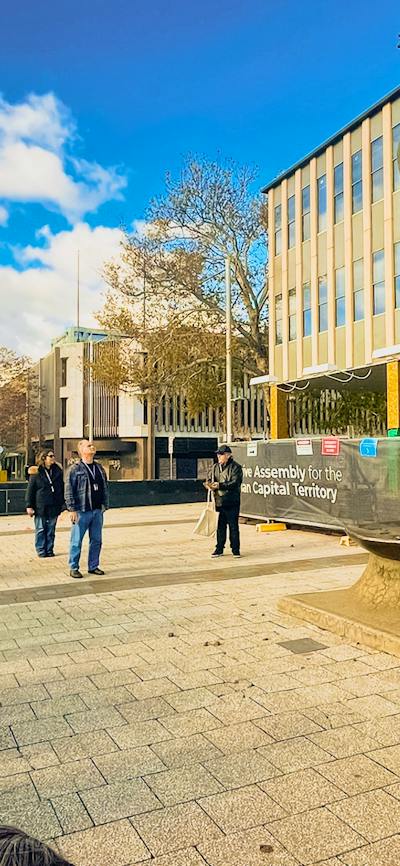 A walking tour group stands in front of the Ethos sculpture at ACT Legislative Assembly