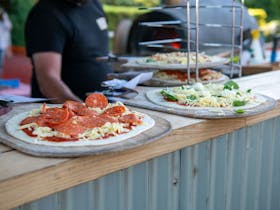 handmade woodfired pizzas being prepared for guests at the summer fiesta