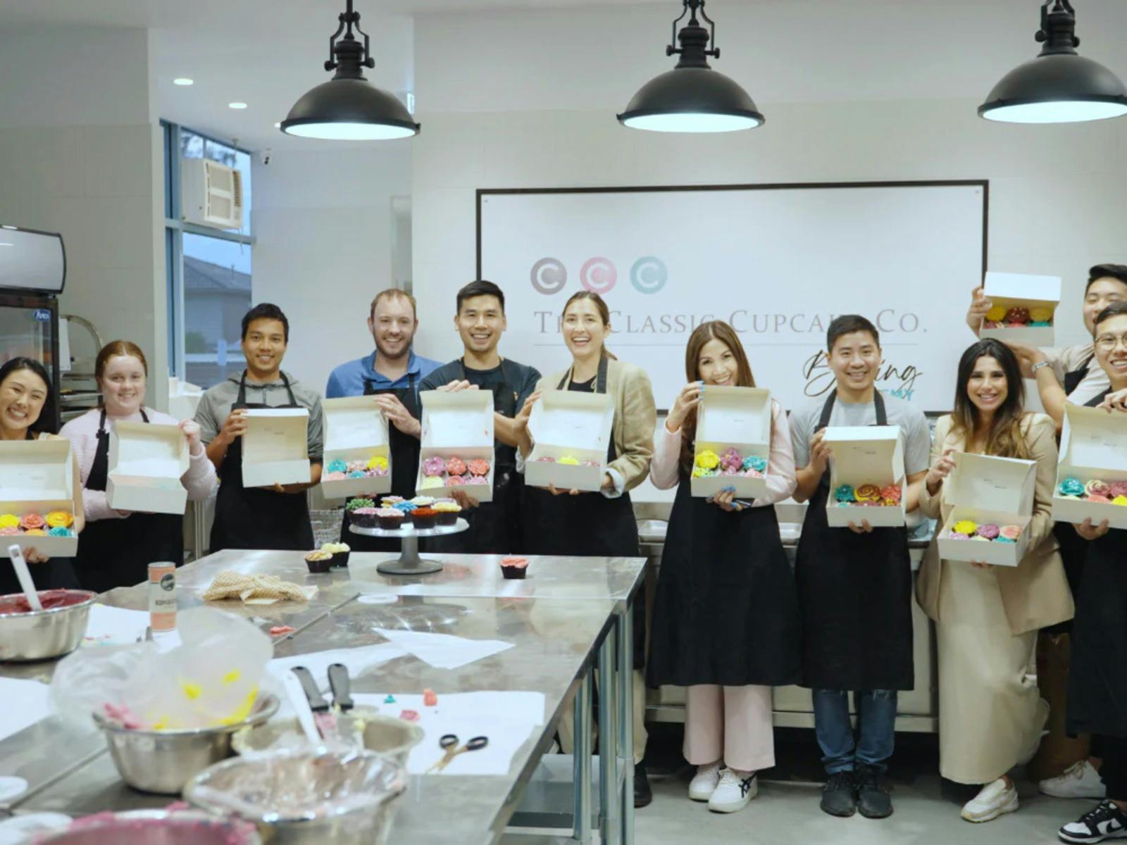 Adult baking classes presenting their made cupcakes
