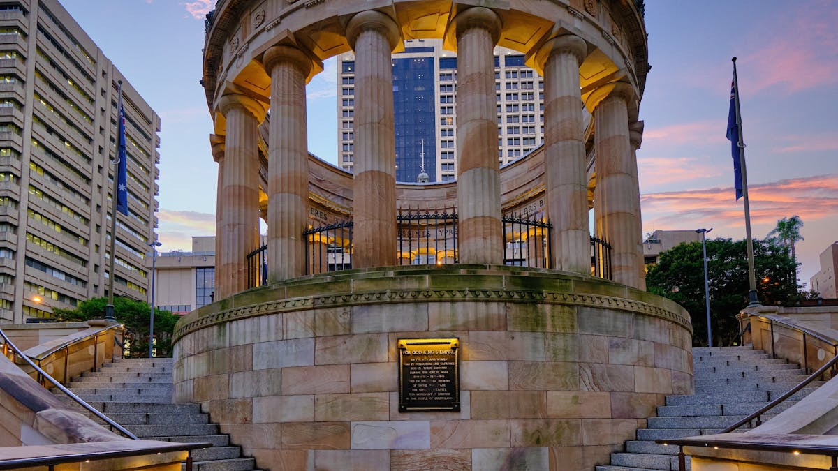 Sandstone war memorial set against sunset sky