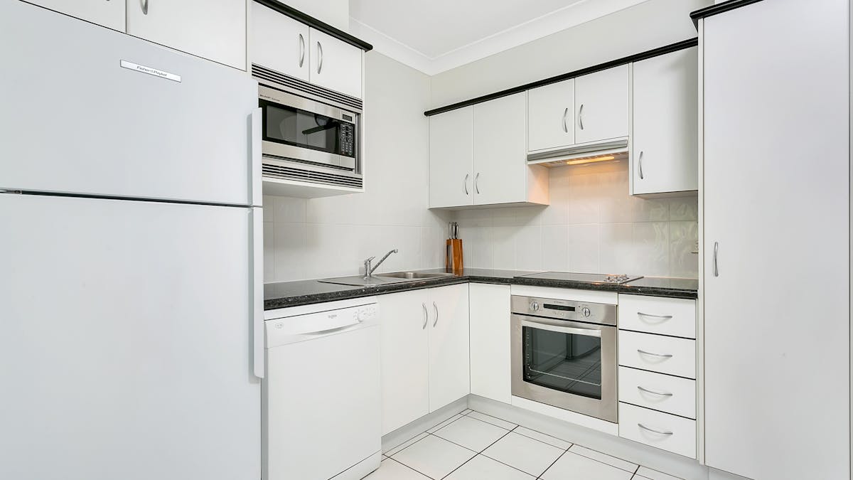 Full sized kitchen with fridge, stove, dishwasher, microwave and dishware.