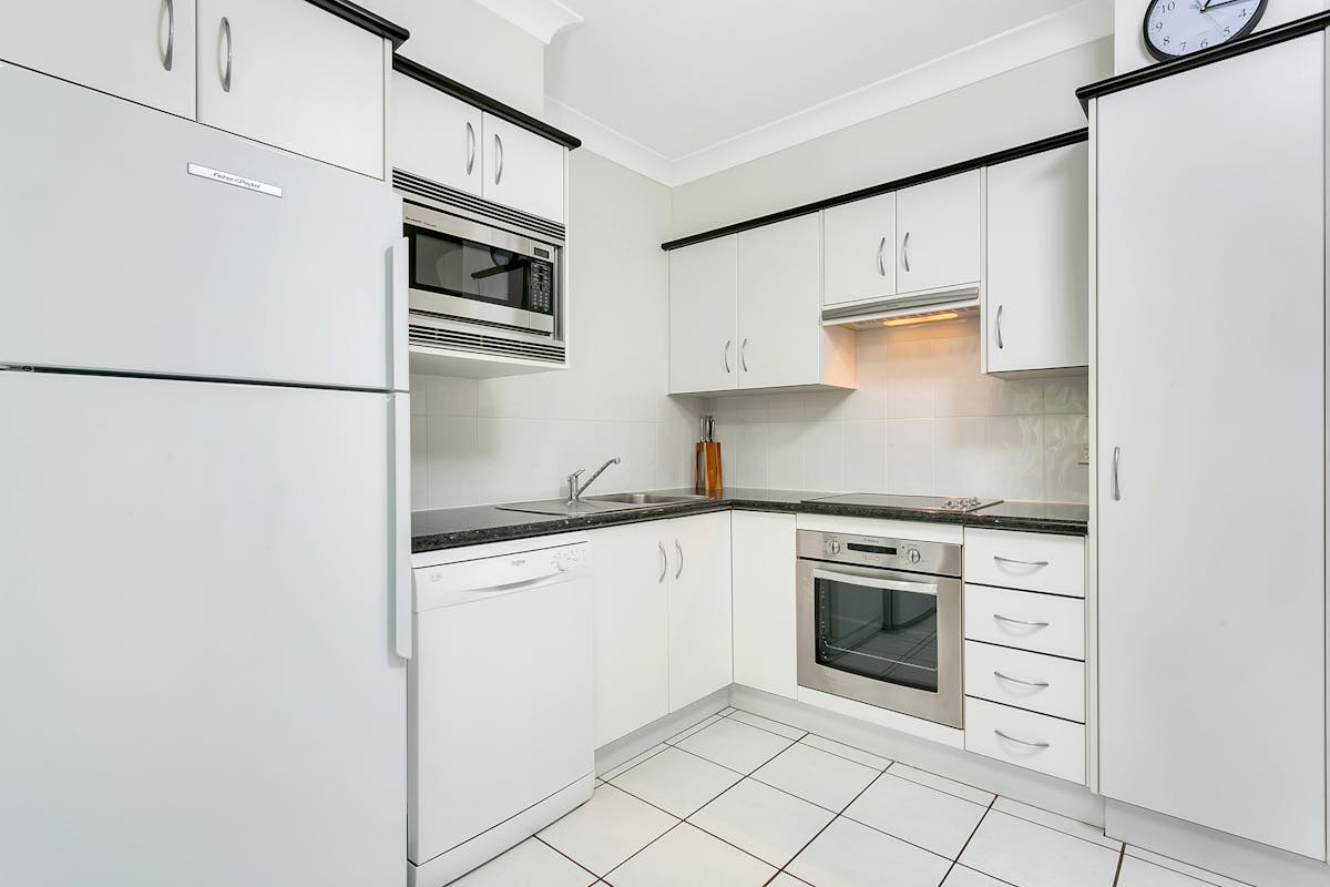Full sized kitchen with fridge, stove, dishwasher, microwave and dishware.