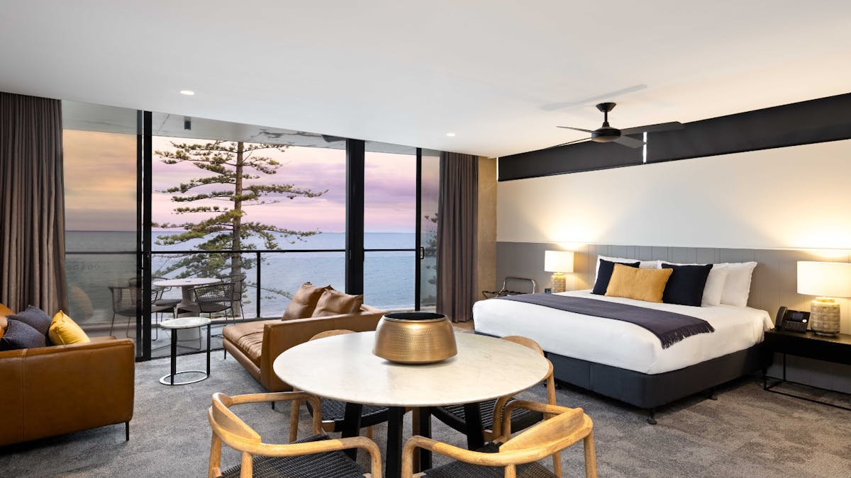 Spacious room with king bed, dining table and views of water