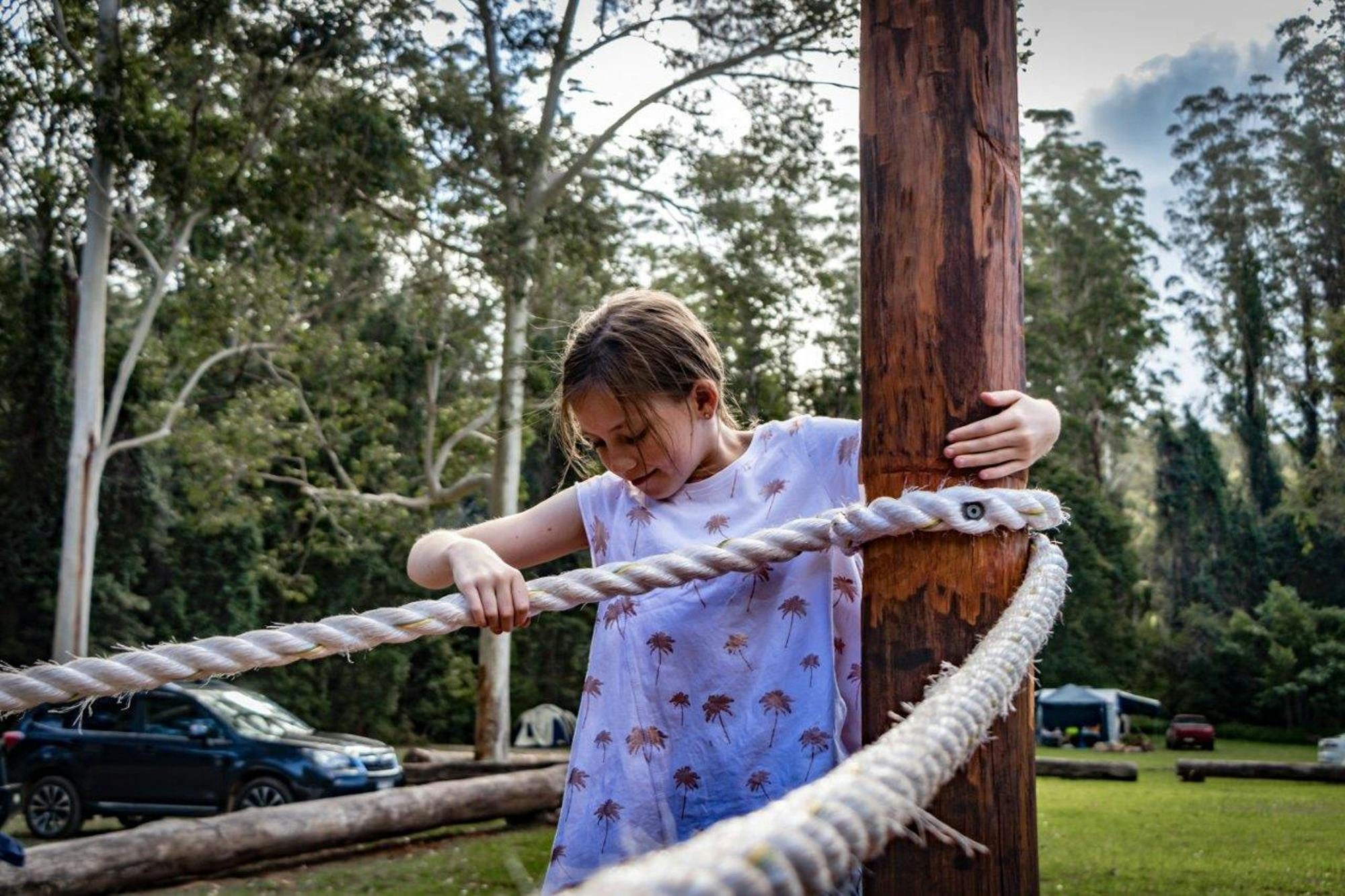 a chil plays on the playground ropes